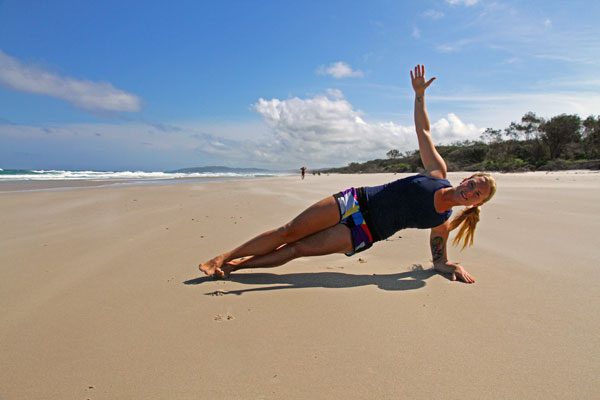 Silje Thorstensen på Tallows Beach i Byron Bay viser sideplanke for surfere